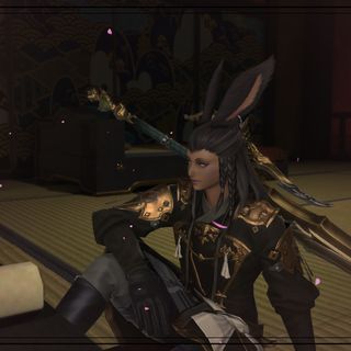 An image of my Warrior of Light, Yasa Enerea, sitting beside a table and looking into the camera.